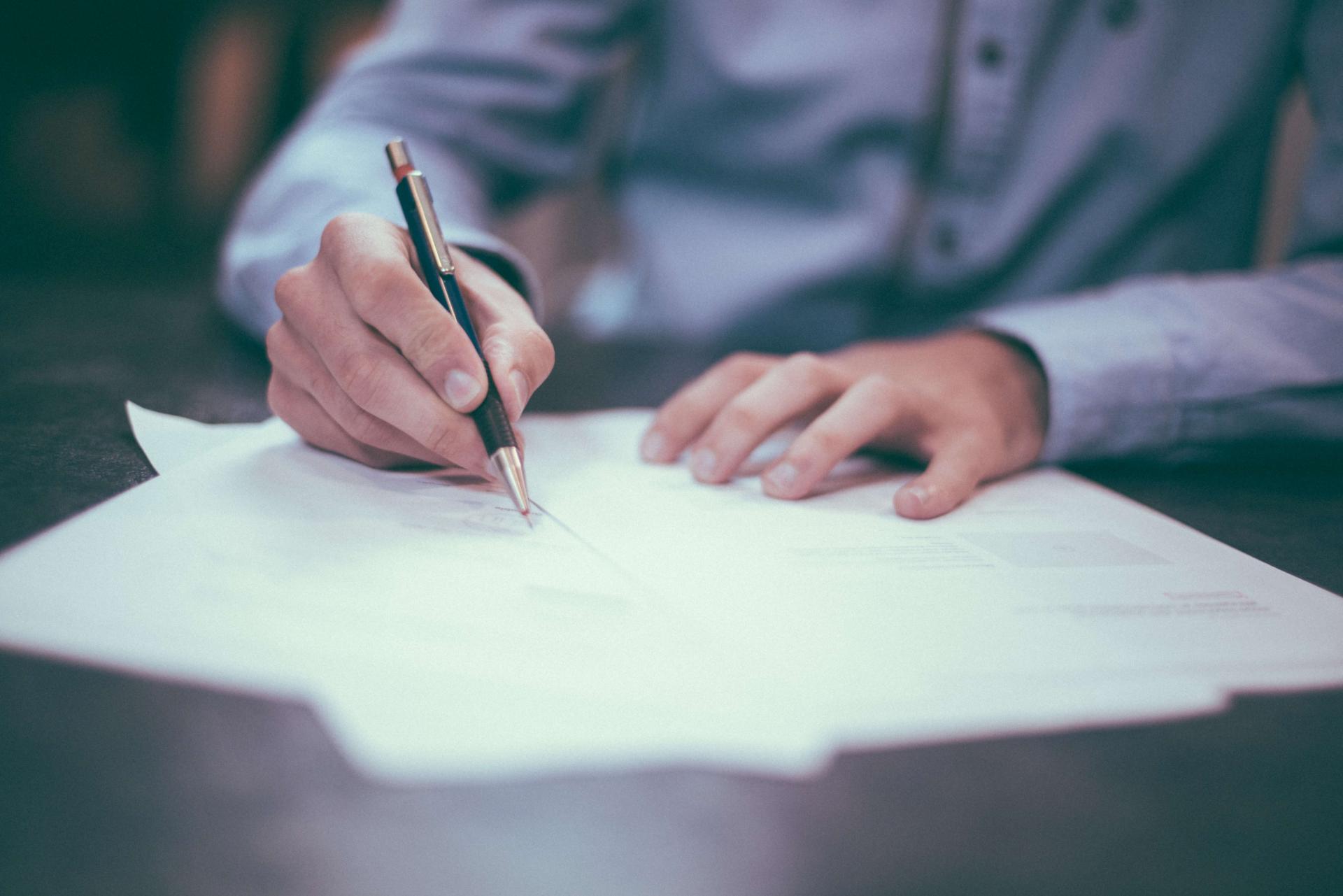 man writing on a piece of paper